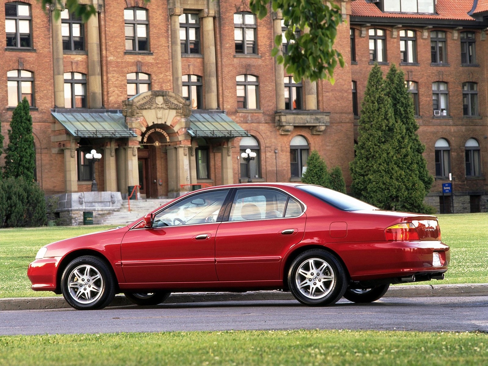 Red sedan parked in front of building