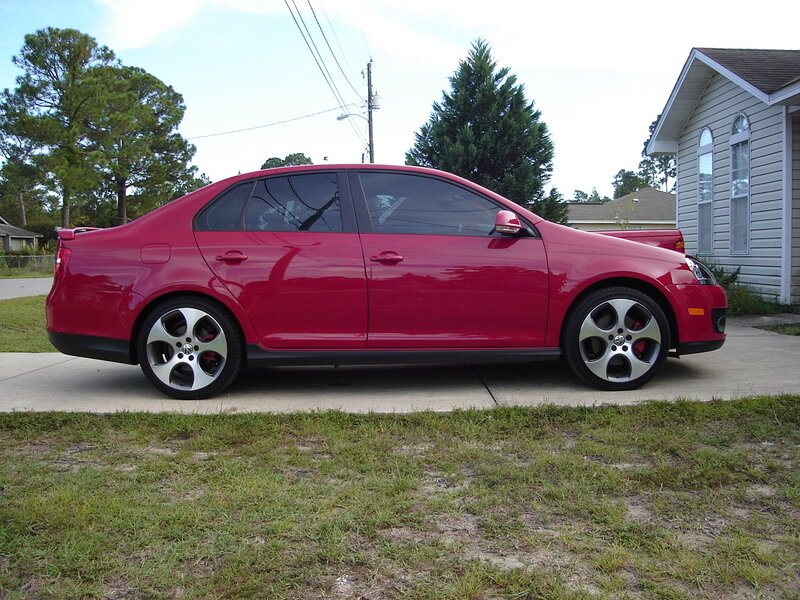 red sedan parked on driveway