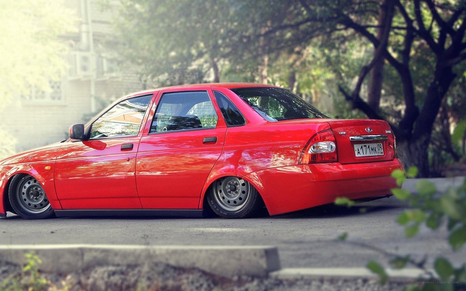Red sedan with custom wheels