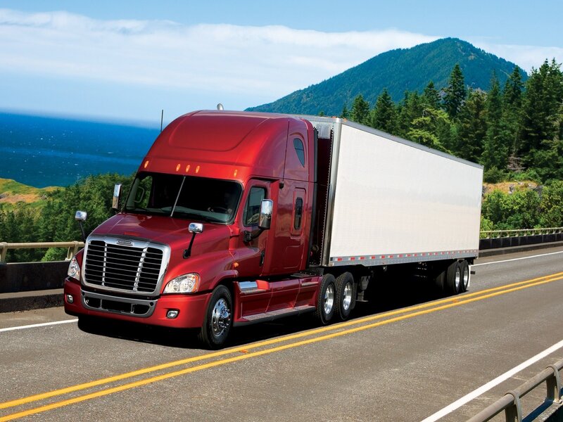 Red semi-truck on coastal highway