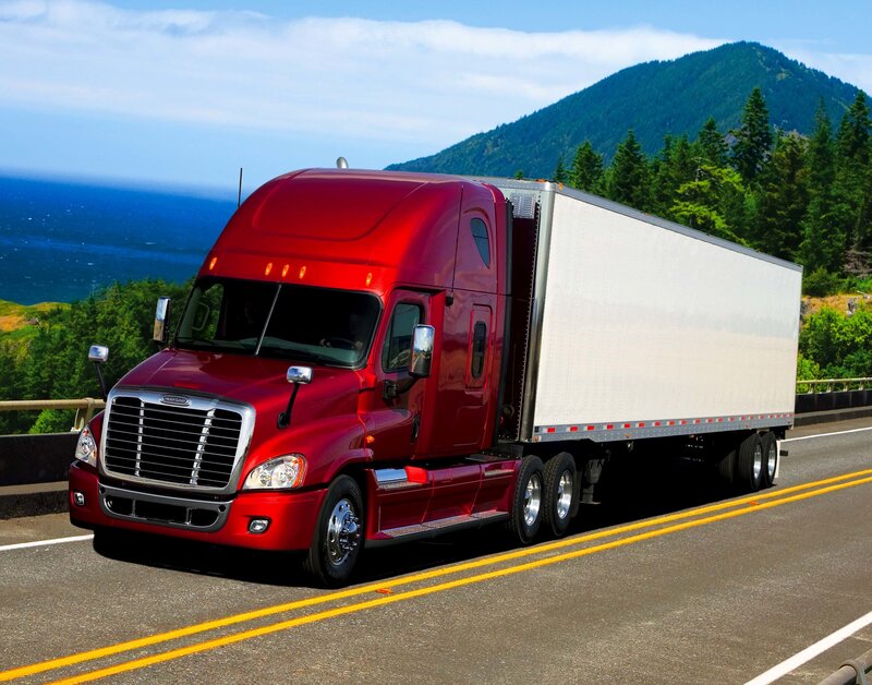Red semi-truck on coastal highway