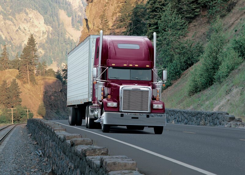 Red semi-truck on mountain road