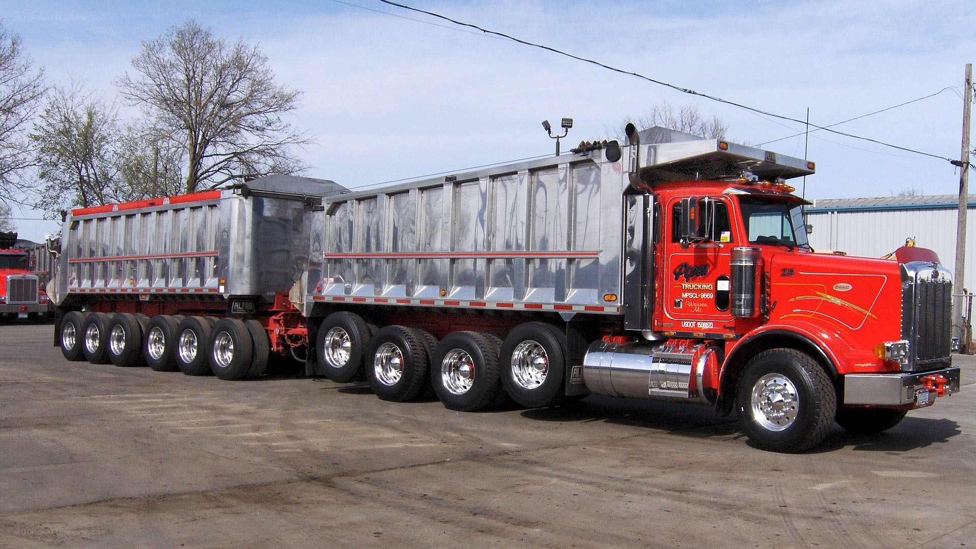 red semi-truck with dump trailers