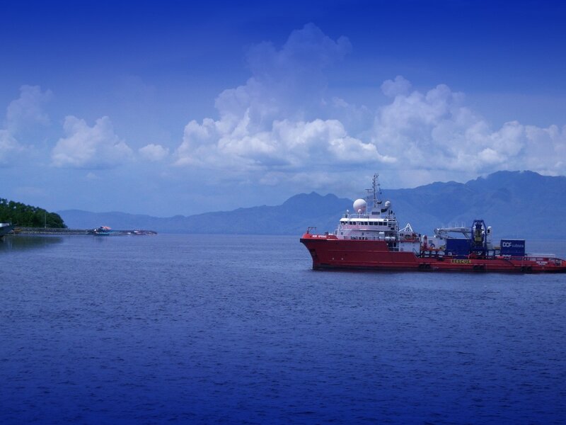 Red ship on calm blue water