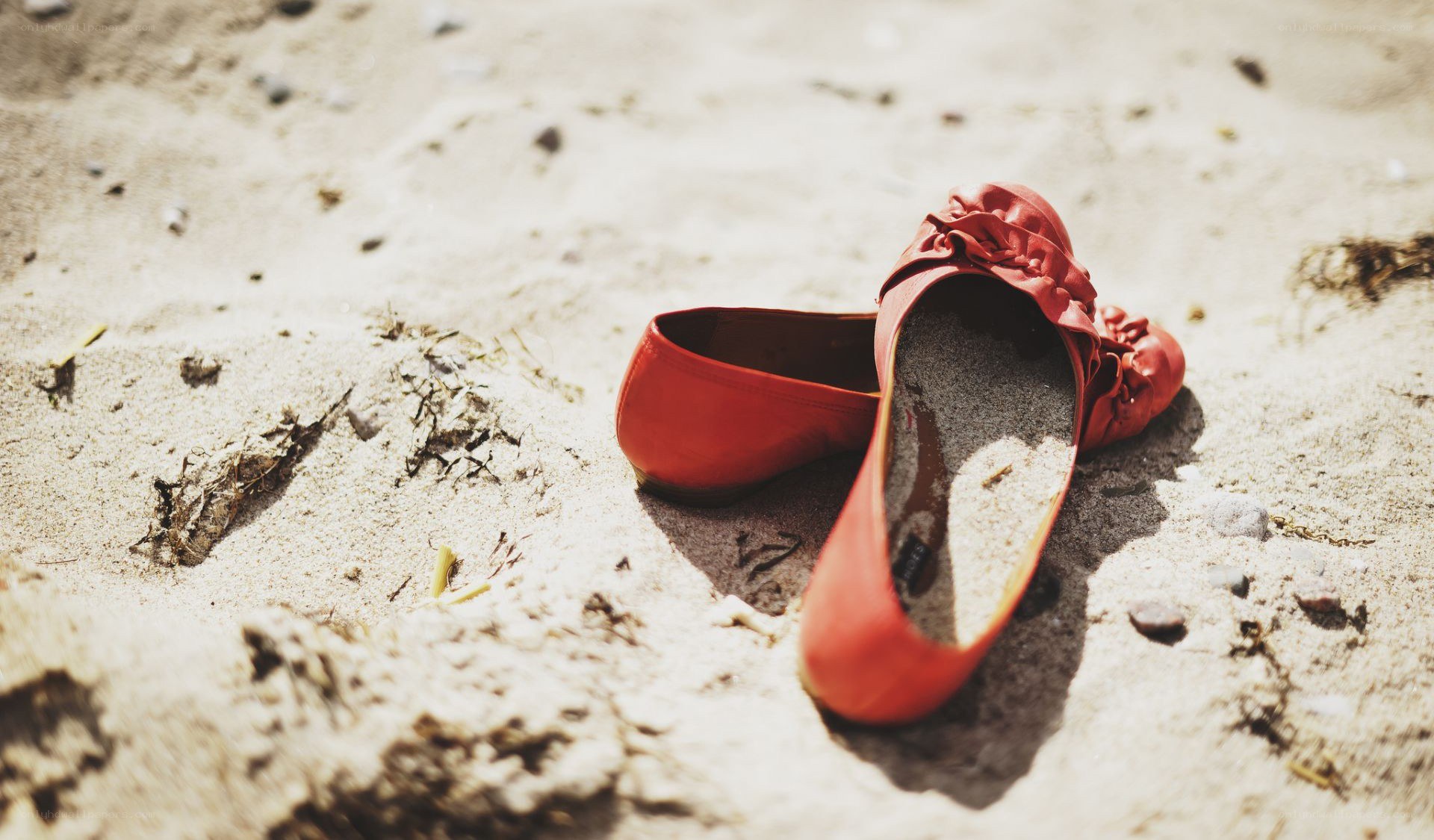 Red shoes on sandy beach