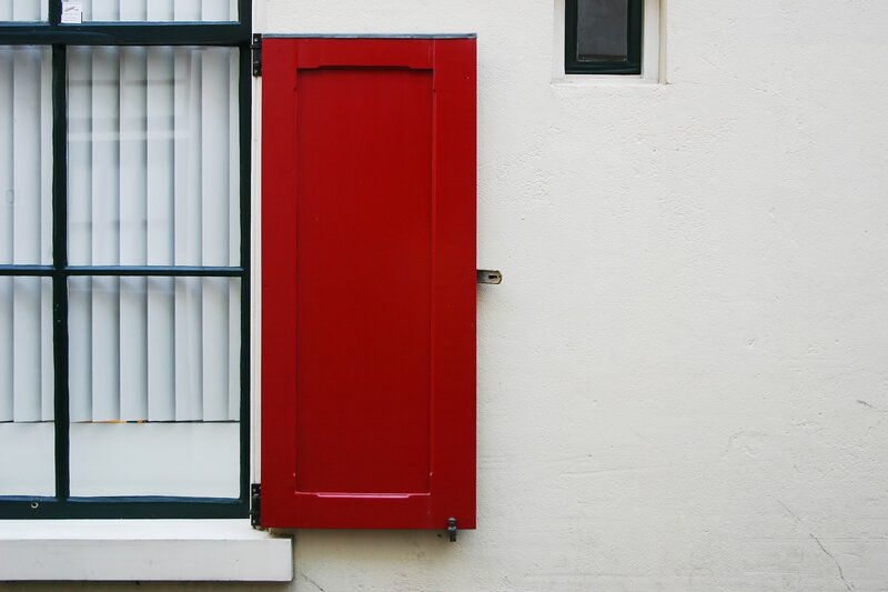 Red shutter on white wall