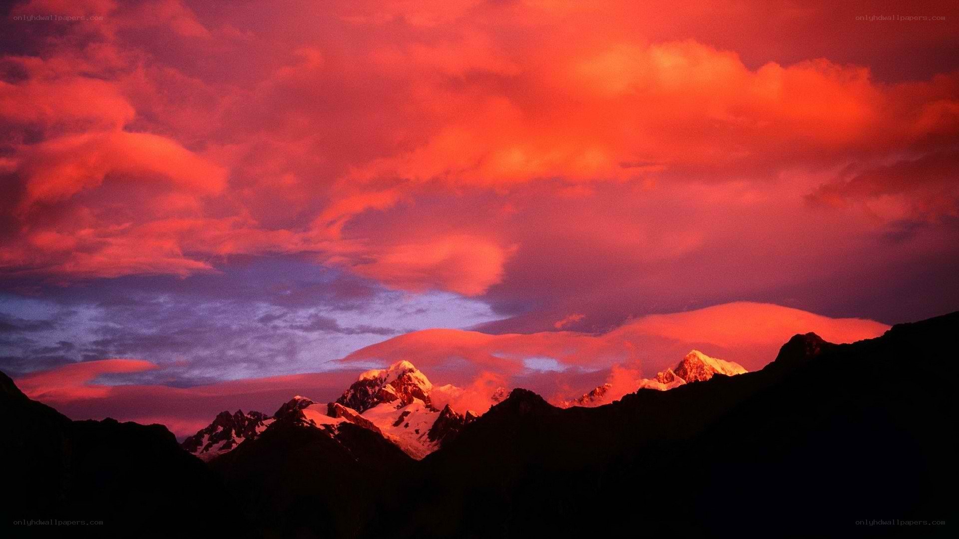 Red sky over snowy mountains