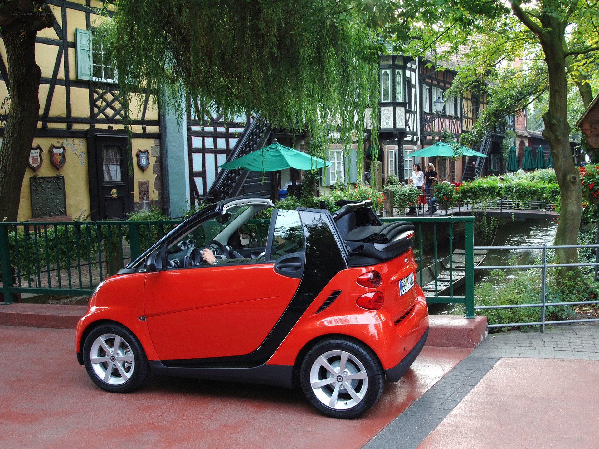 Red smart car by a canal