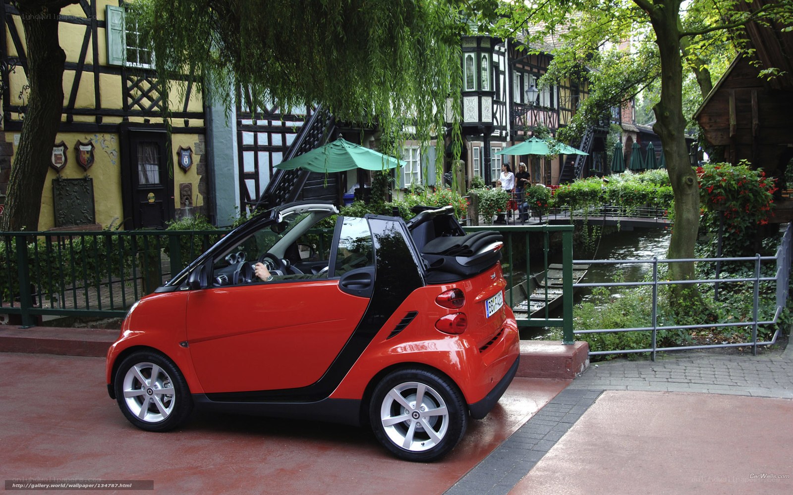 Red smart car on a canal street