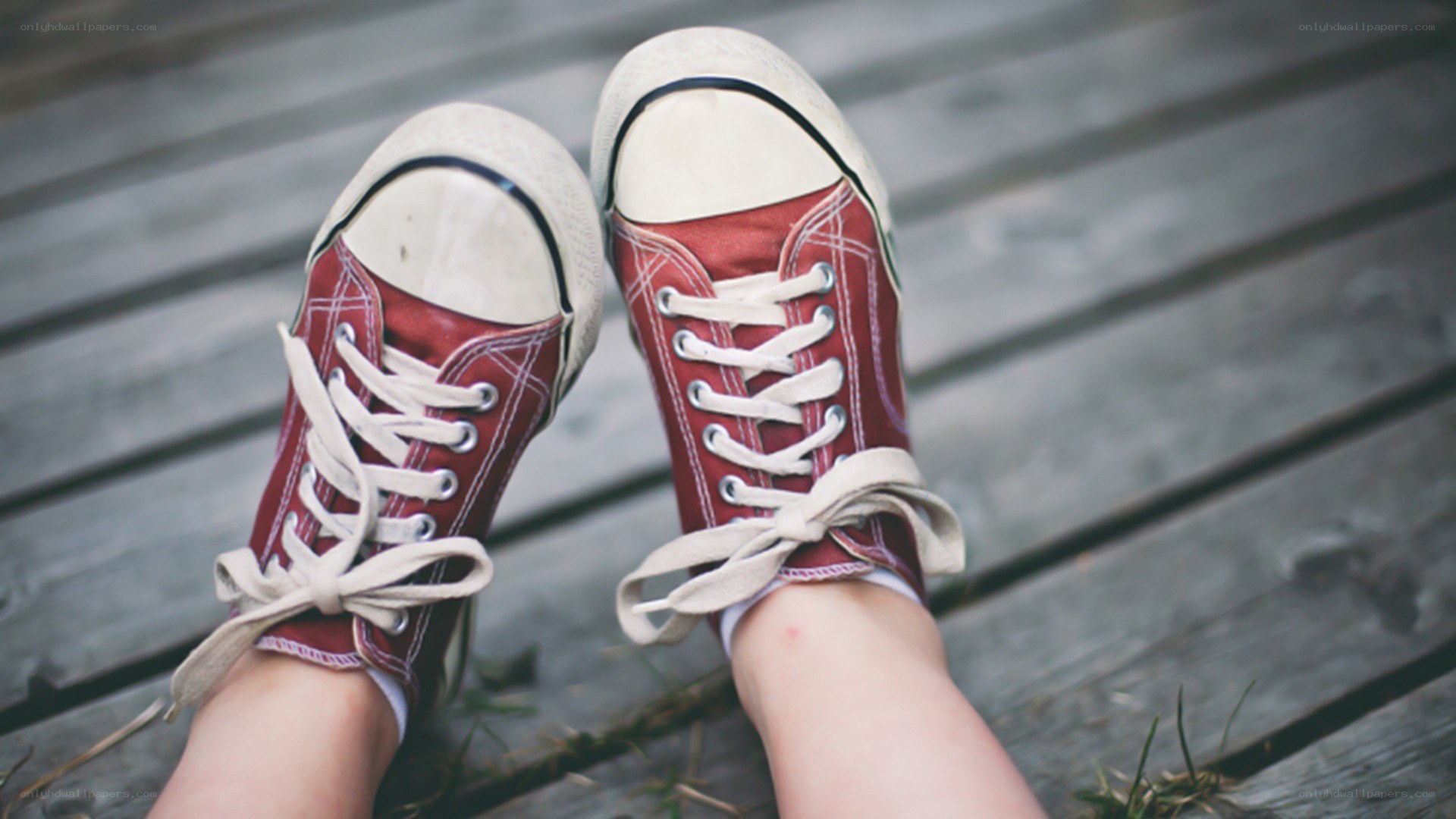 red sneakers on wooden deck
