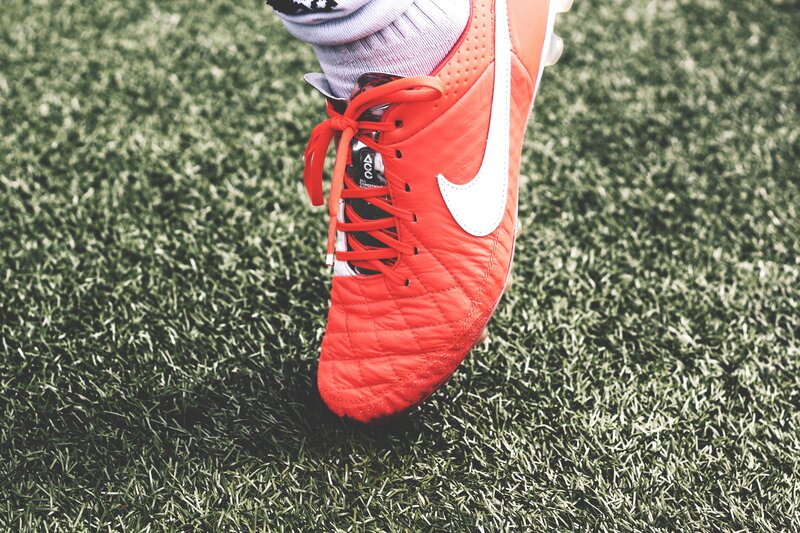 red soccer cleat on turf