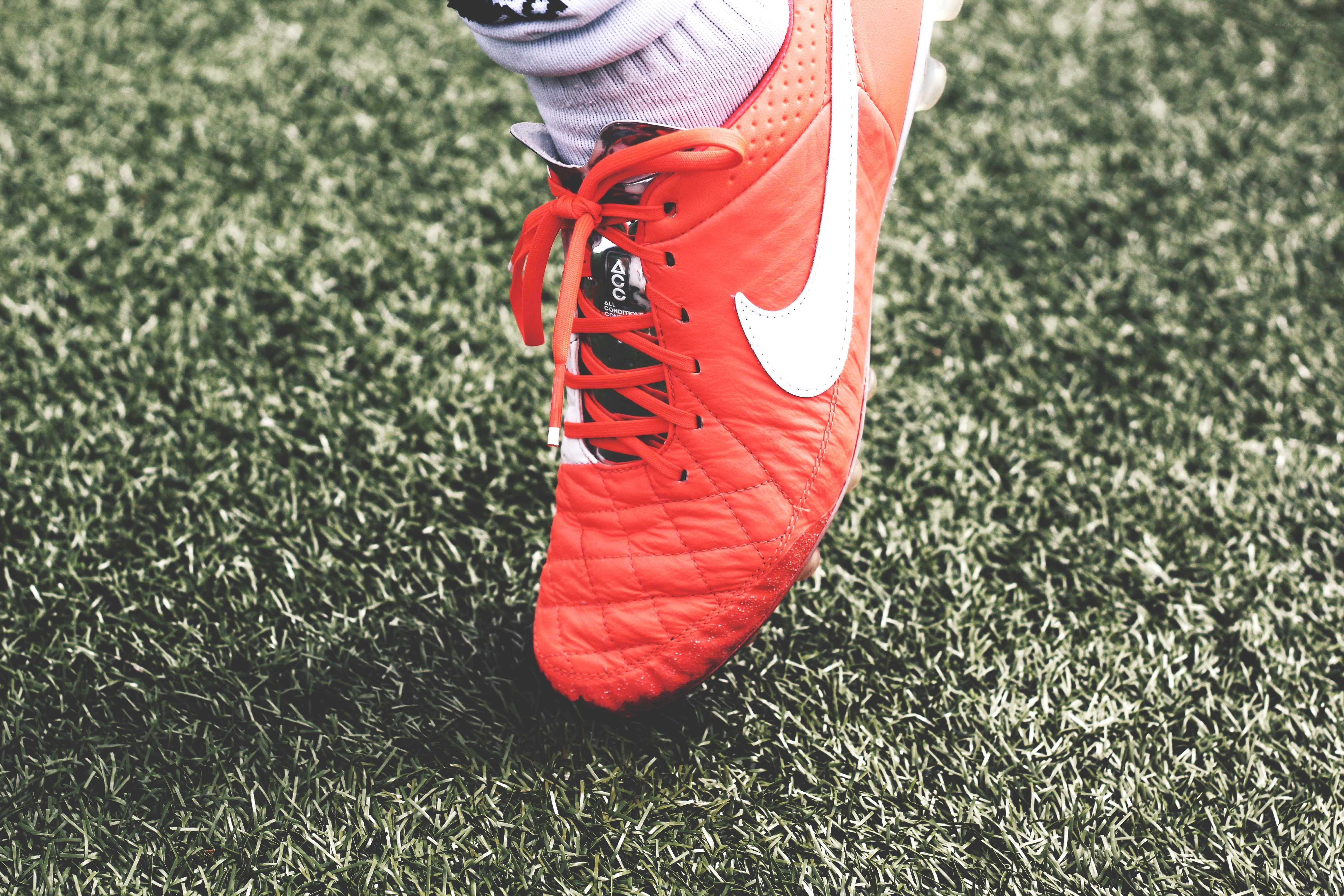 red soccer cleat on turf