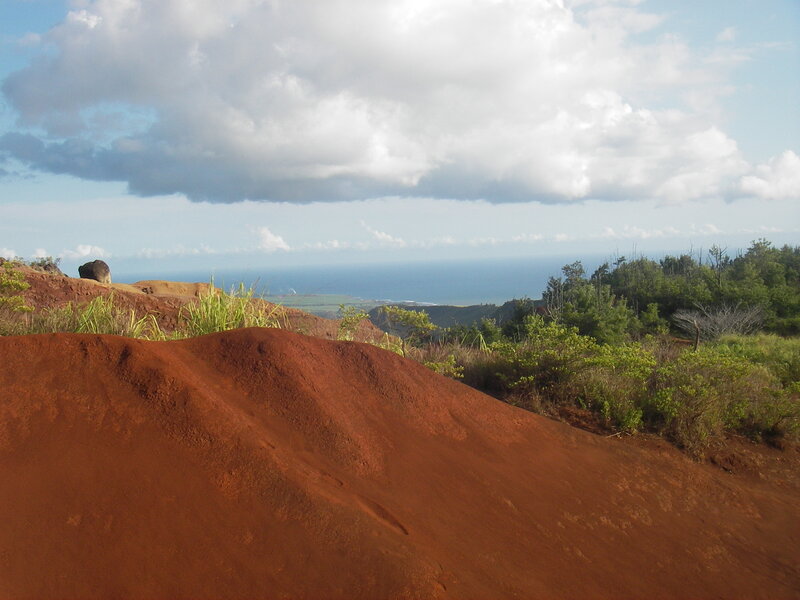 Red soil hill overlooking ocean