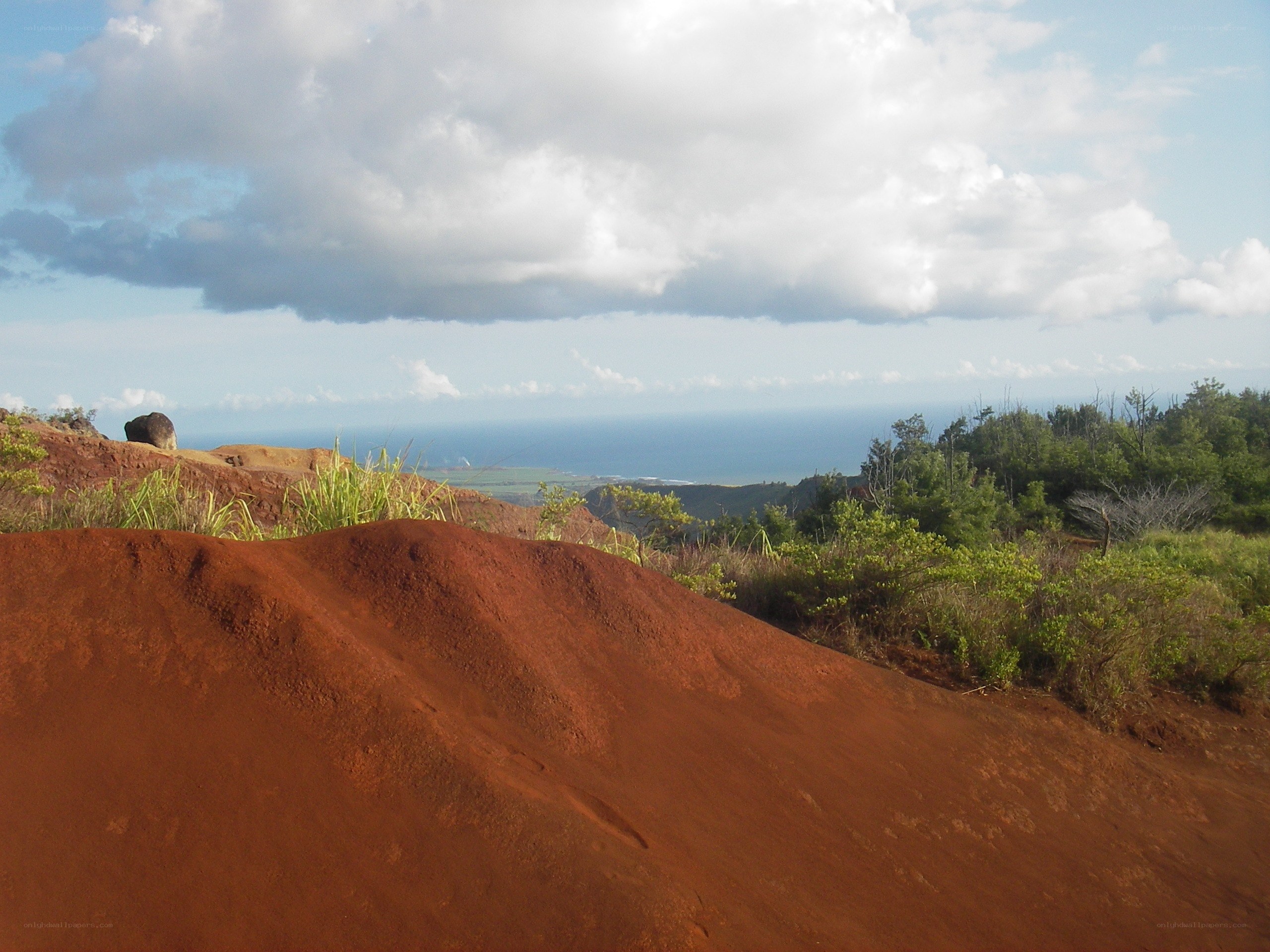 Red soil hill overlooking ocean