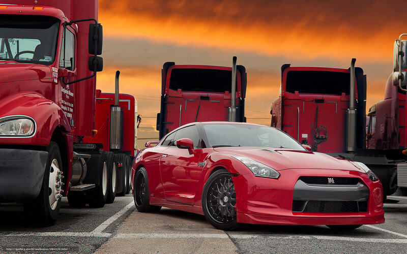 Red sports car between trucks