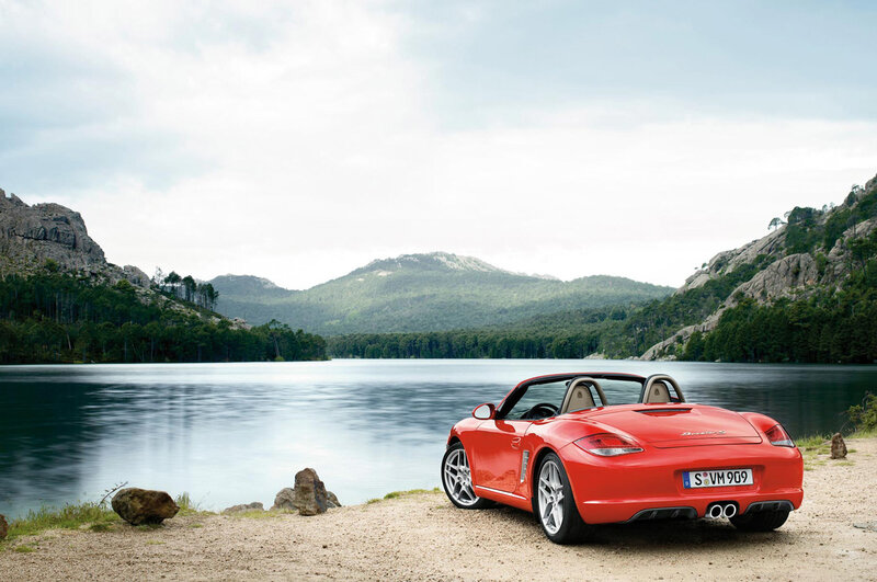 Red sports car by a lake