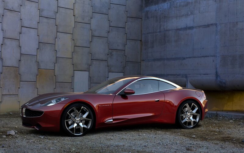 Red sports car by concrete wall