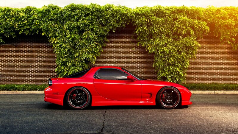 Red sports car by green wall