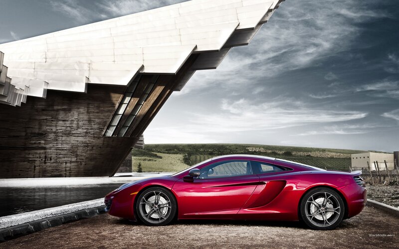 Red sports car by modern building