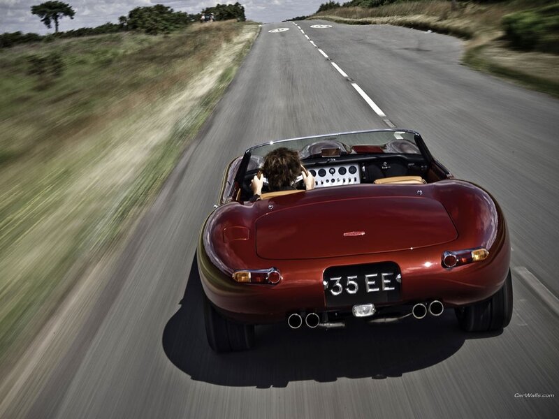 Red sports car driving on road