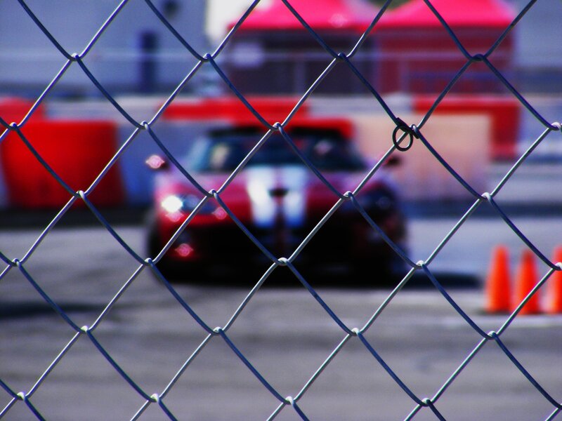 Red Sports Car — Dynamic, Afternoon, Photograph, Chain-link Fence