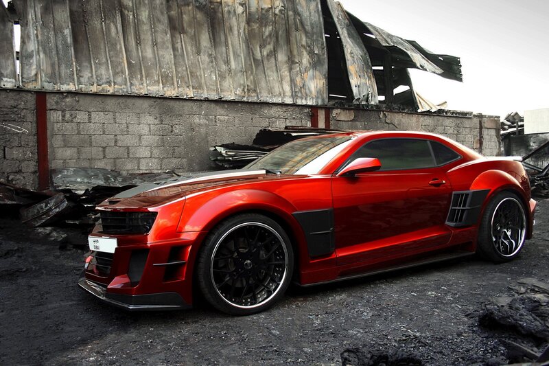 Red sports car in a burnt area