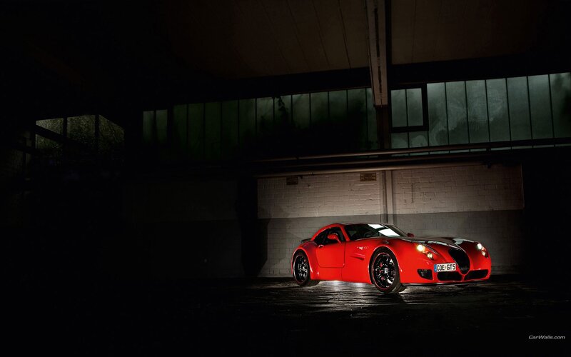 Red sports car in dark garage