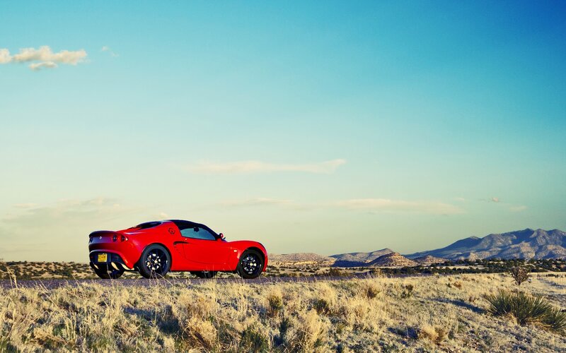 Red sports car in desert landscape