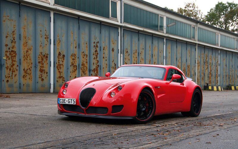 Red sports car in front of garage