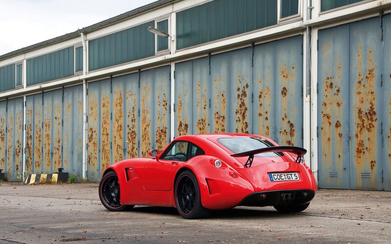 Red sports car in front of garage