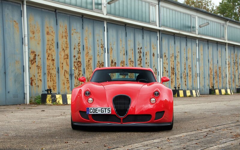 Red sports car in front of garage