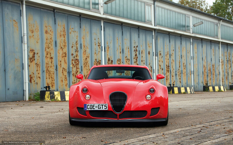 Red sports car in front of garage