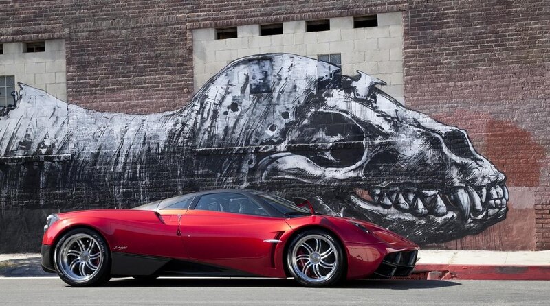 Red sports car in front of skull mural