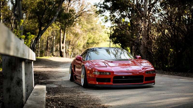 Red sports car on a forest road