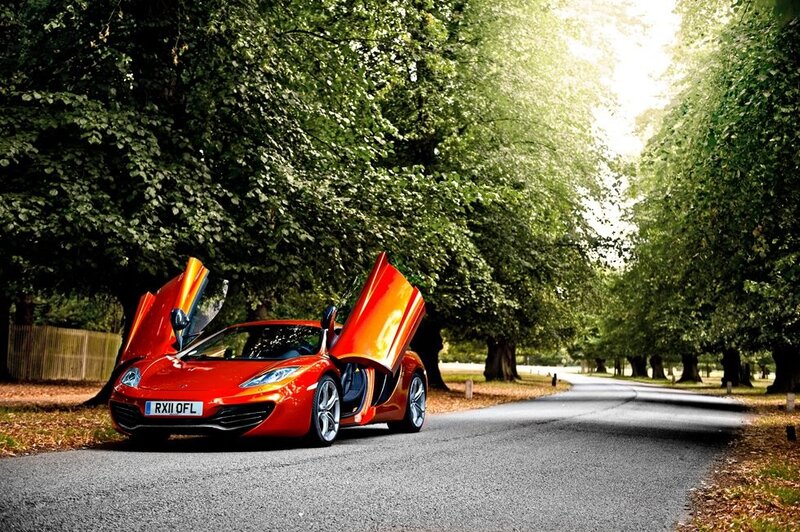 Red sports car on a tree-lined road