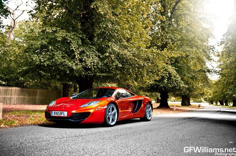 Red sports car on a tree-lined road