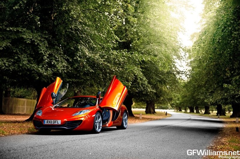 Red sports car on a tree-lined road