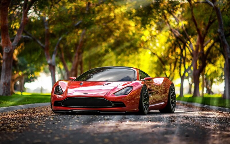 Red sports car on a tree-lined road