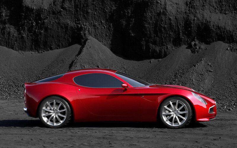 Red sports car on black sand