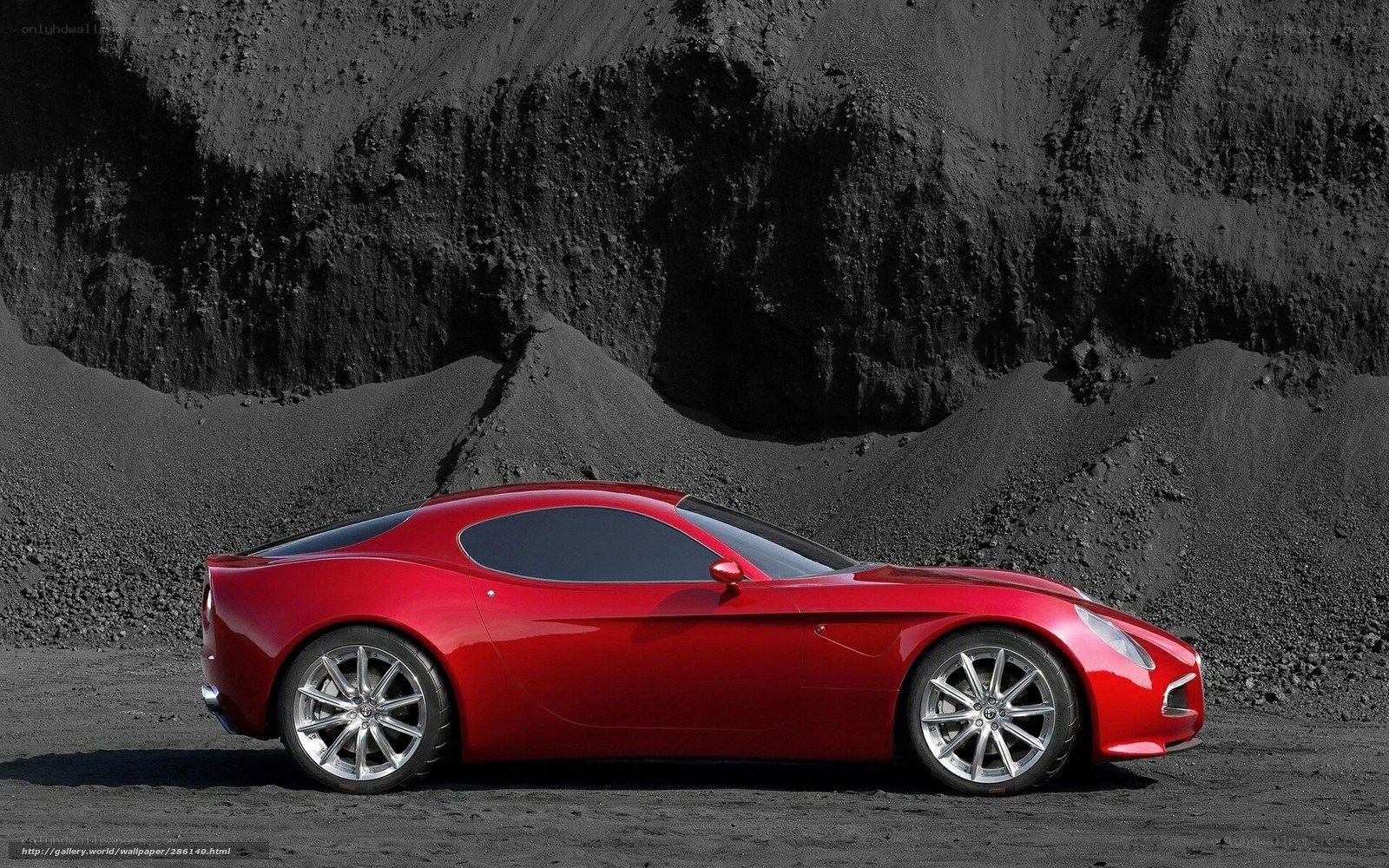 Red sports car on black sand