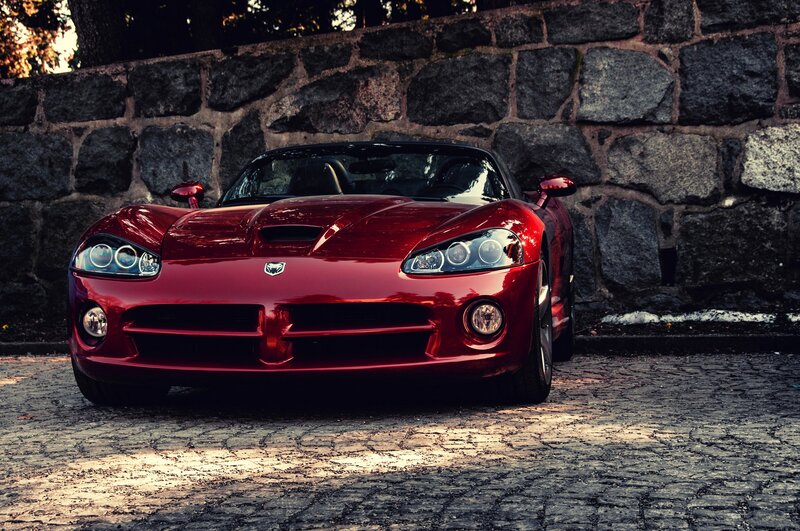 Red sports car on cobblestone