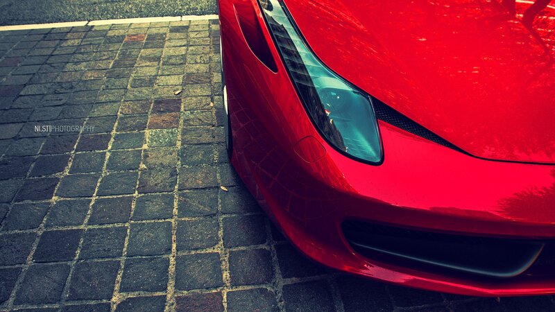 Red sports car on cobblestone