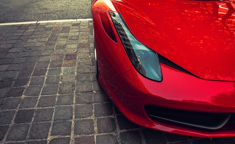 Red sports car on cobblestone