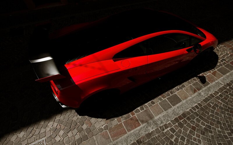 Red sports car on cobblestone