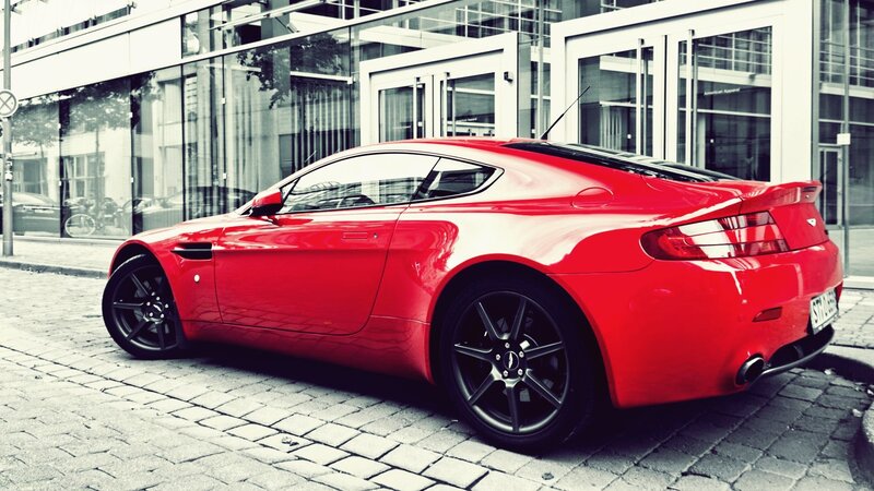 Red sports car on cobblestone street