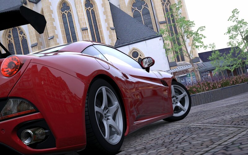 Red sports car on cobblestone street