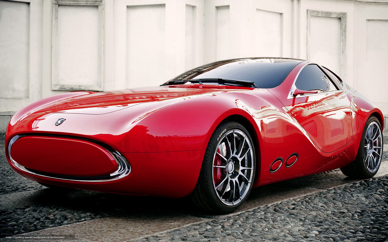 Red sports car on cobblestone