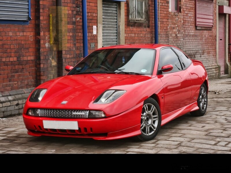 Red sports car on cobblestones
