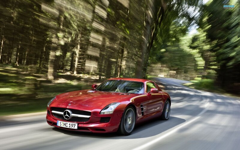 red sports car on forest road