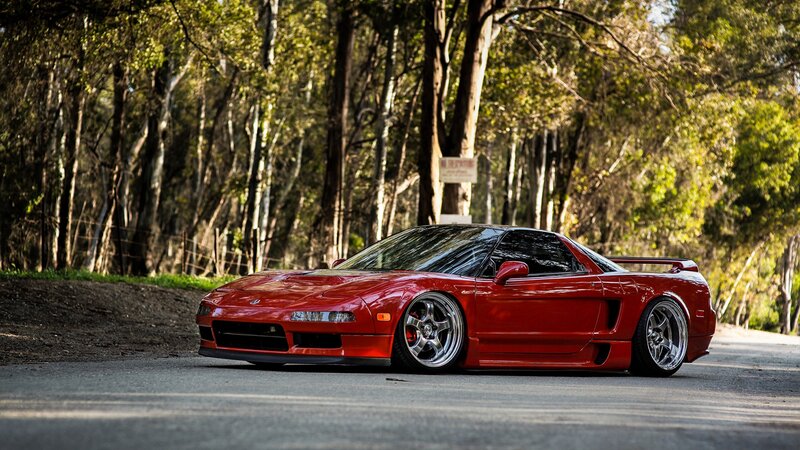red sports car on forest road